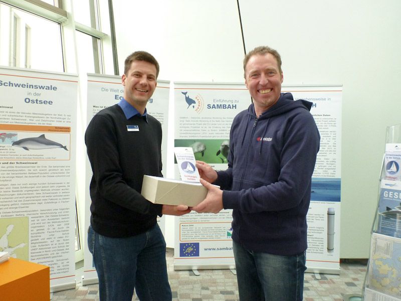 Rene Kaulicke von SeaTrips bekommt den neuen Sichtungsflyer überreicht.